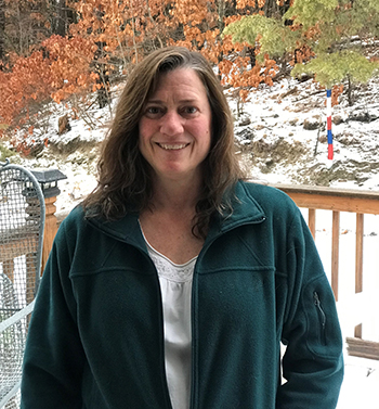A headshort of Michelle Henry standing on a porch overlooking a snowy field