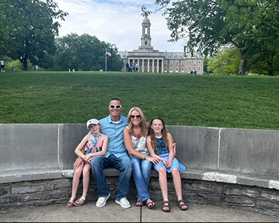 A family sits in front of Old Main.