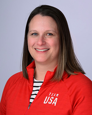 A headshot of a woman wearing a red Team USA jacket.