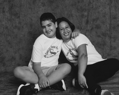 A teenager and a woman sit together in a photography studio.