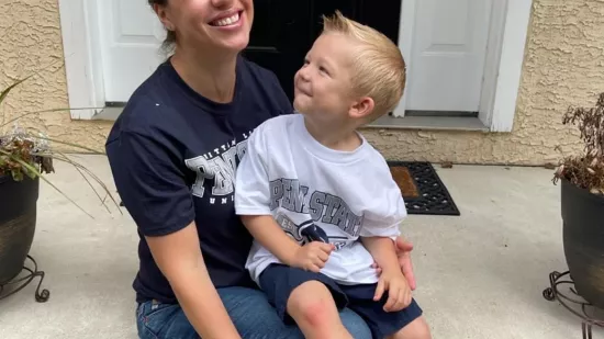 Olga Bernhardt poses for a photo with her young son on her porch.