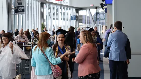 A group of people stand in the concourse of the Mount Nittany Club