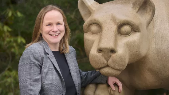 Julie Fitzgerald stands beside the Nittany Lion shrine