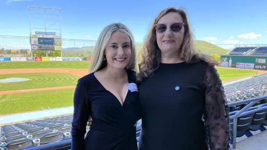 Maite Barrenechea stands with her mom with a baseball field in the background