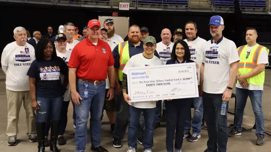 A group of people pose with a large check.