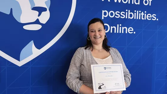 A woman holds a certificate against a backdrop of the logo of World Campus.