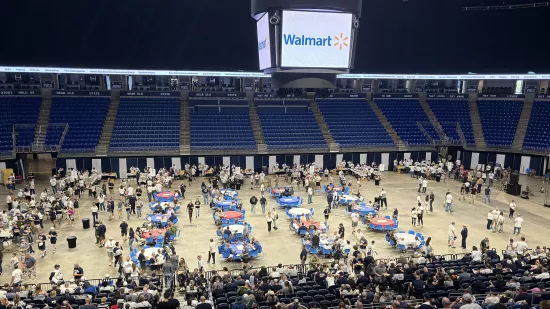 People gathered on the floor of an indoor arena.