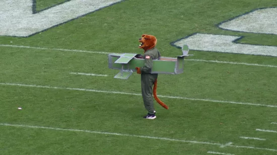 The Nittany Lion mascot walks on a football field.