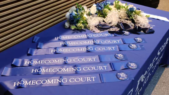 Blue and white flowers and blue sashes on a blue table.