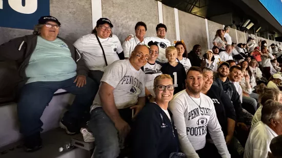 A group of people sitting in a large outdoor stadium.