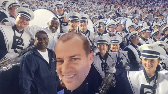 A group of people pose with a large cutout of Devon Love's face.