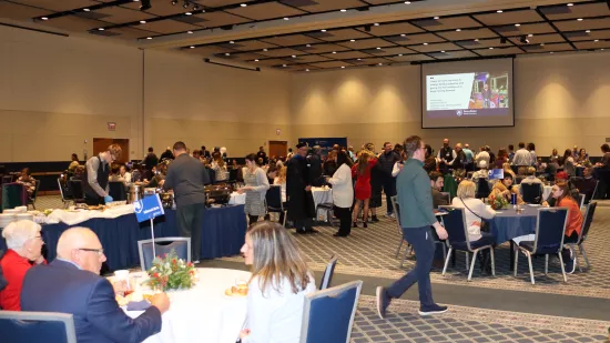 People sit and walk in a ballroom.