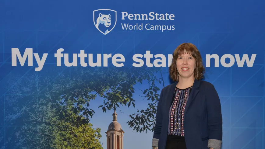 A woman stands in front of a Penn State-themed backdrop.